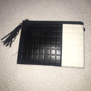Black and white synthetic patent leather clutch.